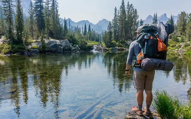 Accueil - Maison Akasha Yoga Randonneur avec sac à dos au bord d’un lac de montagne, activité en pleine nature