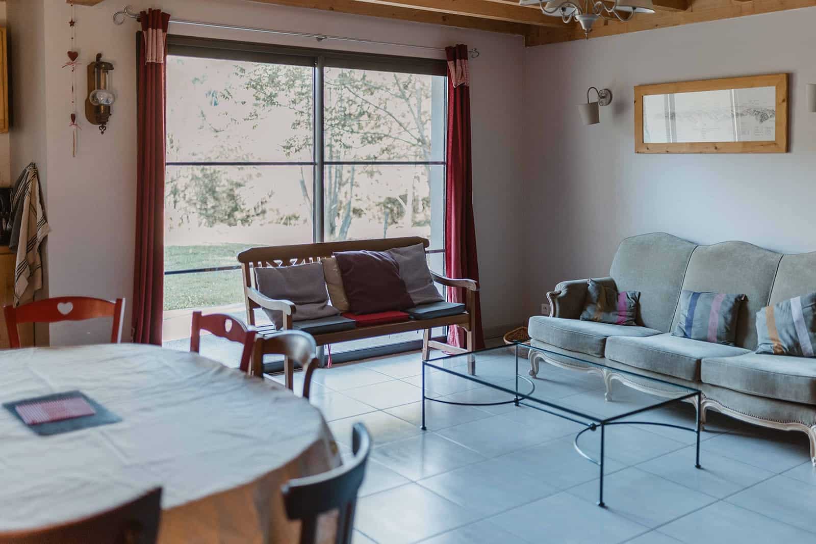 Hébergement - Maison Akasha Yoga Séjour lumineux avec canapé et grande baie vitrée