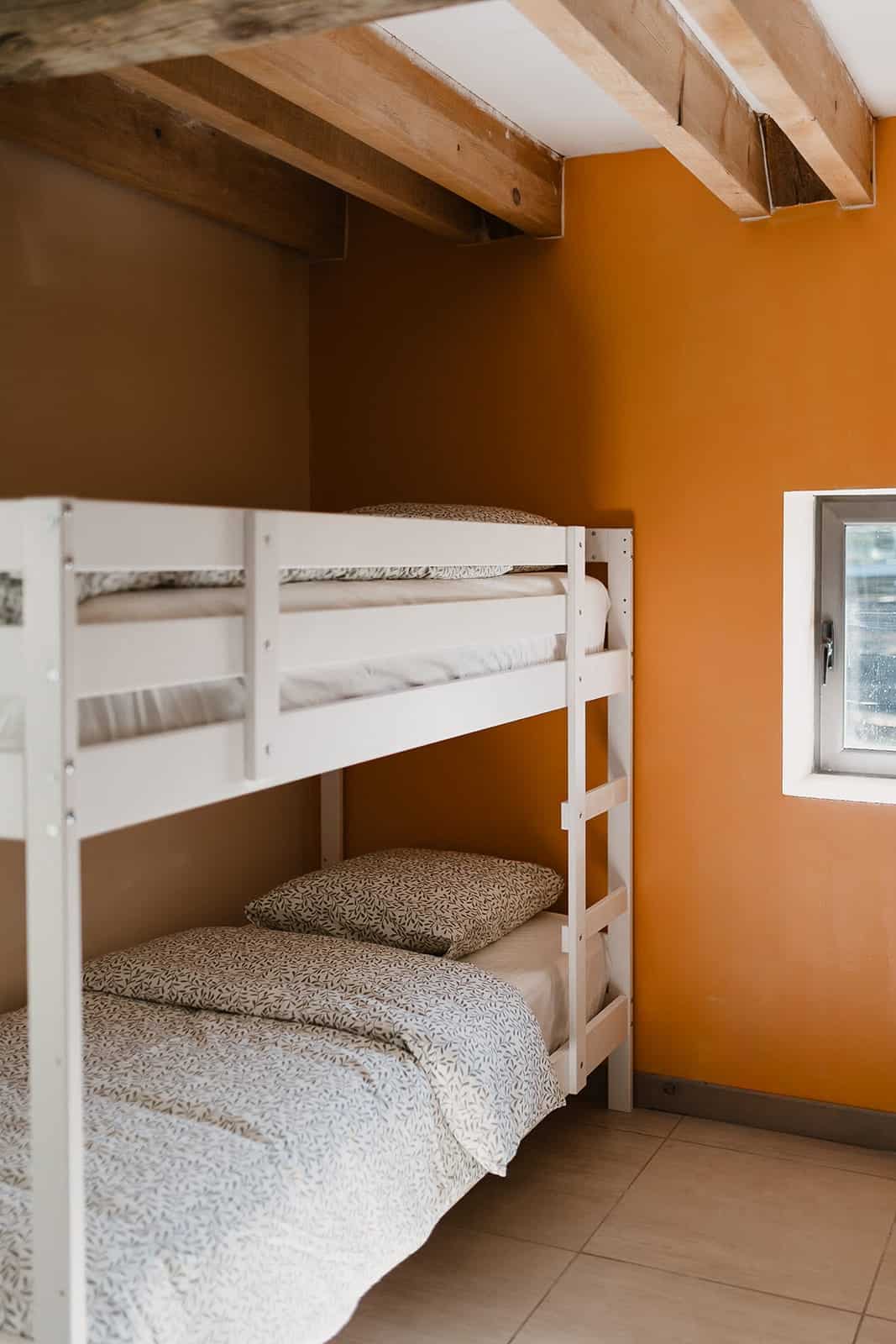 Hébergement - Maison Akasha Yoga Lits superposés dans une chambre aux murs orangés