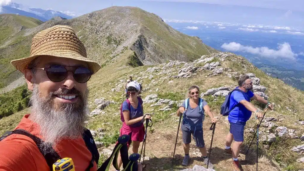 Randonnée sur une crête des Pyrénées – stage yoga et randonnée Maison Akasha Randonneurs souriants, bâtons en main, sur une crête des Pyrénées pendant un stage yoga et randonnée Maison Akasha