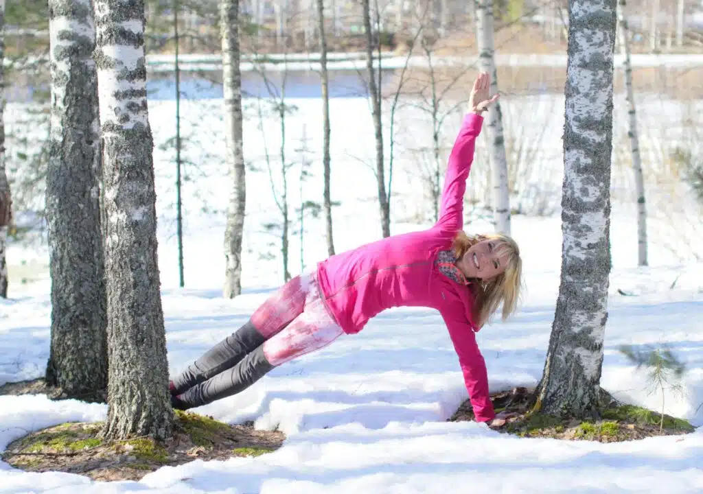 Silence et présence dans une forêt enneigée – élément Éther Posture de yoga immobile dans une forêt enneigée, moment de silence et de présence pendant un stage d’hiver