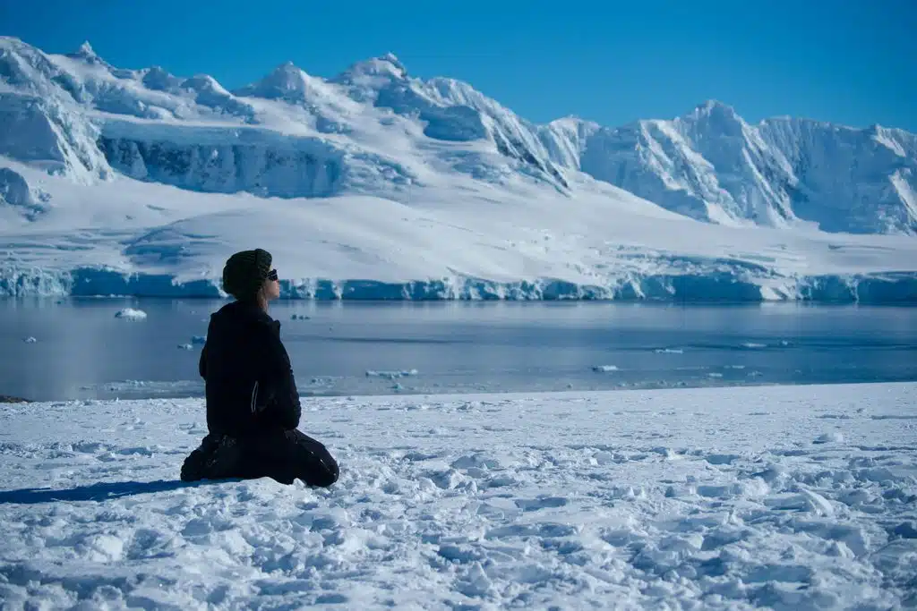 Méditation face aux montagnes enneigées – élément Éther Personne méditant face à un glacier et à des sommets enneigés : les bienfaits de la méditation, élément Éther