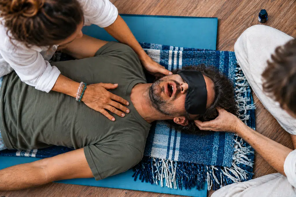 Séance de breathwork guidée, allongé les yeux couverts – élément Air Homme allongé les yeux couverts d’un masque pendant une séance de breathwork guidée : breathwork, bienfaits et dangers, élément Air
