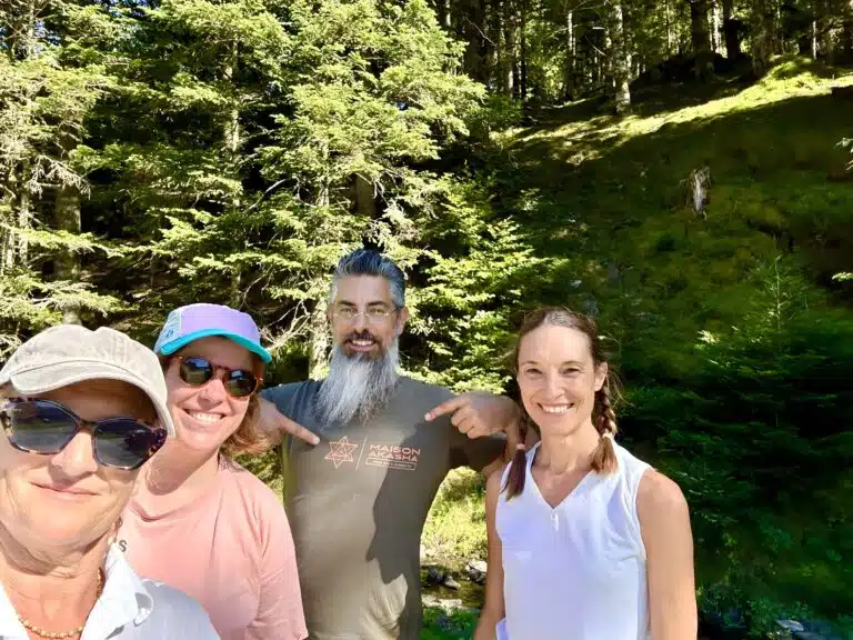 Livre d'Or - Maison Akasha Yoga Selfie de groupe en forêt : trois stagiaires entourent un homme barbu qui montre le logo Maison Akasha de son t-shirt