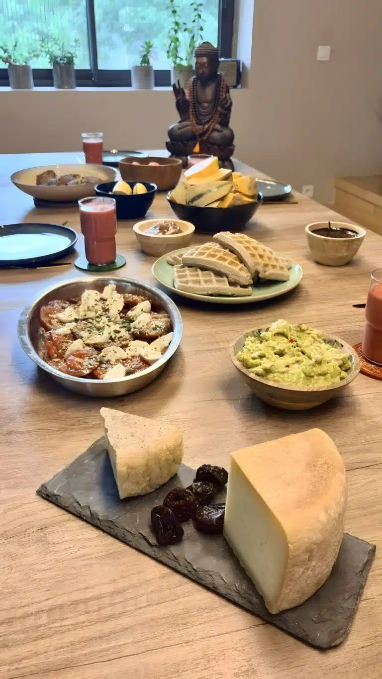 Livre d'Or - Maison Akasha Yoga Ardoise garnie de deux fromages de montagne et de pruneaux, guacamole et tomates-mozzarella sur la table du brunch
